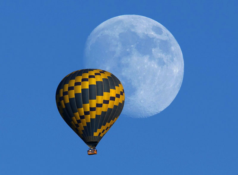 a-hot-air-balloon-floats-past-an-almost-full-rising-moon-on-a-warm-fall-evening-near-encinitas-california-on-october-5-2014