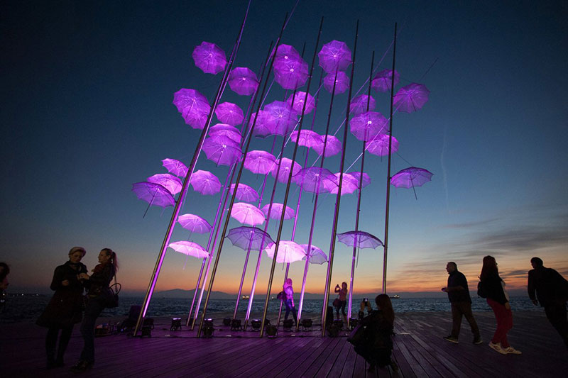 people-stand-around-umbrellas-the-sculpture-by-giorgos-zogolopoulos-as-its-illuminated-in-pink-light-to-mark-breast-cancer-awareness-month-in-thessaloniki-in-northern-greece-october-21-2014